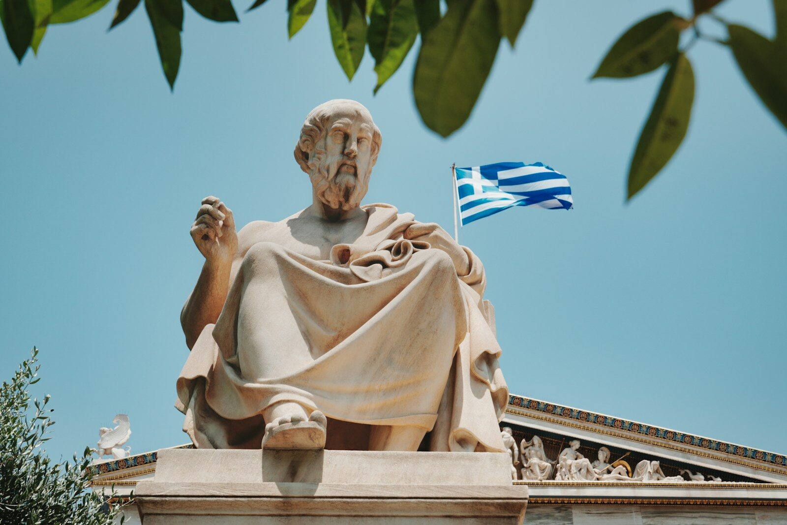 Statue of plato with the greek flag.